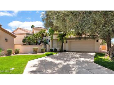 Charming single-Gathering home featuring a well-maintained lawn, mature trees, and a two-car garage at 10421 N 100Th St, Scottsdale, AZ 85258