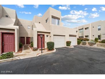 Two-story townhome with two-car garage and landscaped entrance provides a welcoming curb appeal at 11260 N 92Nd St # 1014, Scottsdale, AZ 85260