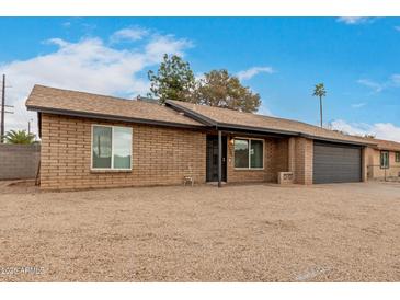 Charming single-story brick home featuring a two-car garage and a low-maintenance desert landscape at 1201 S 80Th St, Mesa, AZ 85209