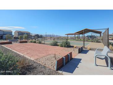 A bright community area featuring a bocce ball court, shuffleboard, and tennis court with mountain views at 17322 W Jessie Ln, Surprise, AZ 85387