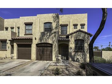 Inviting townhome featuring a two-car garage, covered entryway, and neutral color scheme at 1943 E Hayden Ln # 103, Tempe, AZ 85281