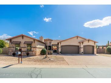 Stunning single-story home featuring a stone facade, three-car garage, and desert landscaping at 10649 E Saddle Blanket Trl, Gold Canyon, AZ 85118