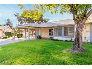 Charming single-story home with a carport, lovely lawn, and mature trees on a sunny day at 11671 S Jokake St, Phoenix, AZ 85044