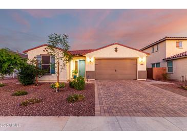 Charming single-story home featuring a brick driveway, manicured landscaping, and a two-car garage at 3739 S 180Th Dr, Goodyear, AZ 85338