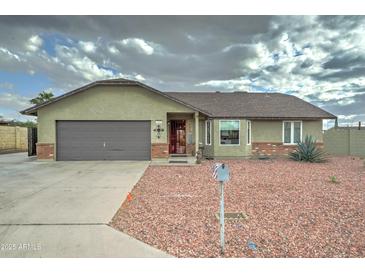 Charming single-story home featuring desert landscaping, a two-car garage, and a welcoming entrance at 6461 E Jensen St, Mesa, AZ 85205