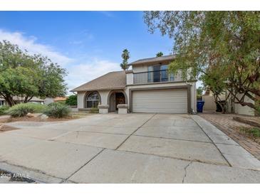 Charming two-story home featuring a balcony, arched entry, desert landscaping and a spacious driveway at 843 W Nido Ave, Mesa, AZ 85210