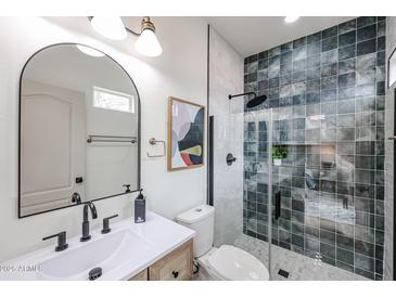 A stylish bathroom with modern fixtures, including a black-framed shower and a decorative mirror at 859 S Bristol --, Mesa, AZ 85208