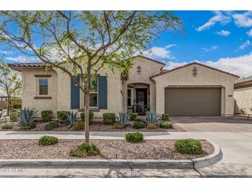 Charming single-story home featuring a meticulously landscaped front yard and an attached two-car garage at 10717 E Tarragon Ave, Mesa, AZ 85212