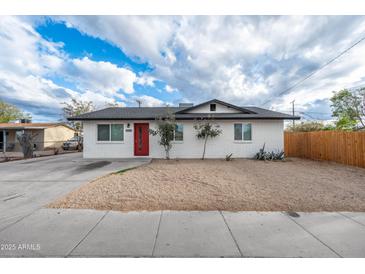 Charming single-story home featuring a red front door and a well-maintained gravel front yard at 10947 W Mohave St, Avondale, AZ 85323