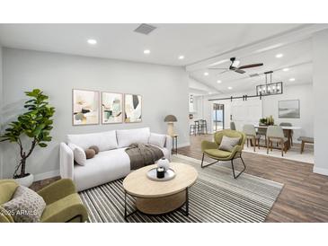 Bright living room featuring a modern sofa, stylish decor, and an open floor plan at 13216 N 48Th Pl, Scottsdale, AZ 85254