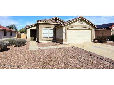 Charming single-level home with a two-car garage and low maintenance desert landscaping in front at 13646 W Fargo Dr, Surprise, AZ 85374