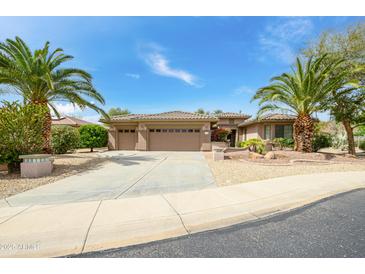 Charming home featuring a three-car garage and meticulously landscaped front yard with desert landscaping at 20562 N Bear Canyon Ct, Surprise, AZ 85387