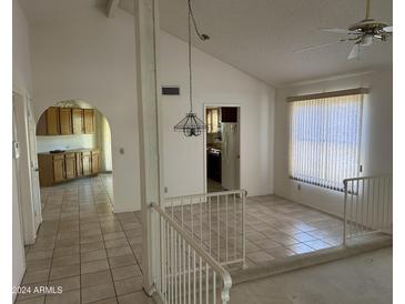 Bright living room featuring tile floors, a ceiling fan, neutral paint, and a half wall with decorative railing at 4537 E Shomi St, Phoenix, AZ 85044