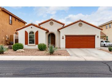 Charming single-story home with a red-tile roof, desert landscaping, and a two-car garage at 7421 W Montgomery Rd, Peoria, AZ 85383