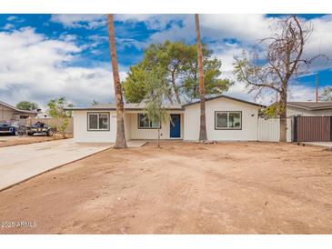 Charming single story home featuring fresh paint, a blue front door, and an expansive front yard at 1900 S Coconino Dr, Apache Junction, AZ 85120