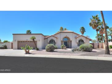 Charming home with desert landscaping, arched windows, and a neutral color palette at 2077 N Lake Shore Dr, Casa Grande, AZ 85122