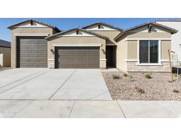 Charming single-story home with a three-car garage, manicured gravel landscaping, and neutral color palette at 4946 W Weeping Willow Way, Laveen, AZ 85339
