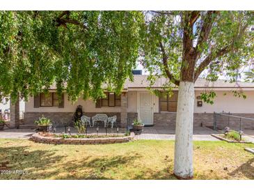Charming single-story home with a well-maintained lawn, mature tree, and inviting facade at 6235 N 25Th Ave, Phoenix, AZ 85015
