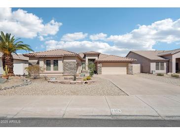 Charming home featuring desert landscaping, stone accents and a spacious driveway leading to a two-car garage at 8004 W Robin Ln, Peoria, AZ 85383
