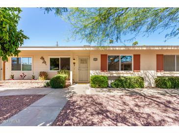 Charming single-story home featuring desert landscaping, light-colored siding, and bright awnings at 10547 W Coggins Dr, Sun City, AZ 85351