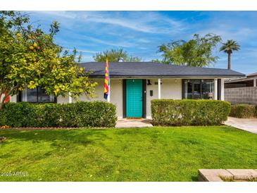Charming single story house with a lush green lawn and a vibrant turquoise door at 1326 E Almeria Rd, Phoenix, AZ 85006