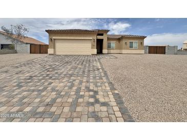 Inviting single-story home featuring a charming facade, paver driveway, gravel landscaping, and an attached two-car garage at 15422 S Sequoia Cir, Arizona City, AZ 85123