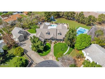 Expansive home featuring an in-ground pool, tennis court, trampoline, large yard, and mature trees at 1632 S Alba Cir, Mesa, AZ 85204