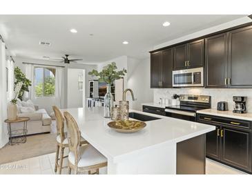Modern kitchen featuring a large island, dark cabinetry, stainless steel appliances, and eat in area at 1679 E Dogwood Ln, Gilbert, AZ 85295
