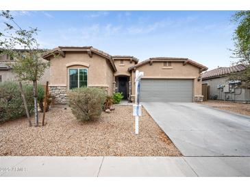 Charming single-story home with desert landscaping, neutral stucco, stone accents, and attached two-car garage at 17545 W Lilac St, Goodyear, AZ 85338