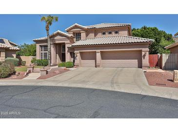 Charming two-story home featuring a tile roof, three-car garage, and well-manicured front yard at 22521 N 60Th Ave, Glendale, AZ 85310