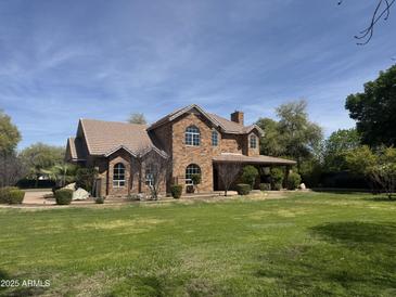Sprawling two-story brick home on a large lot with mature trees and well-manicured lawn at 2904 W Belmont Ave, Phoenix, AZ 85051