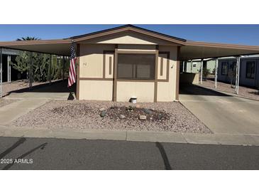 Charming home featuring a covered carport, rock landscaping, and neutral colored exterior at 3330 E Main St # 332, Mesa, AZ 85213