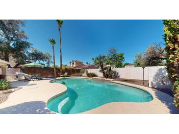 Beautiful backyard pool with lush landscaping, perfect for cooling off on hot summer days at 6720 W Mcrae Way, Glendale, AZ 85308