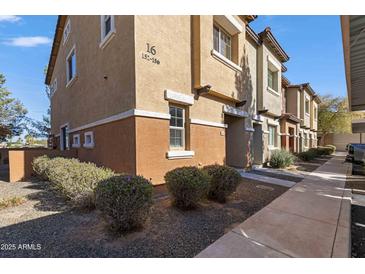 Two-story condo showcases neutral toned stucco and neatly trimmed landscaping; numbered '16' is visible at 7726 E Baseline Rd # 156, Mesa, AZ 85209