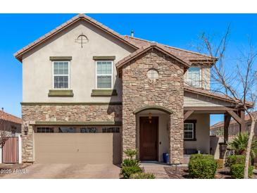 Charming two-story home features a stone facade, attached two-car garage, and manicured landscaping at 10162 E Theorem Dr, Mesa, AZ 85212
