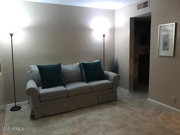 Cozy living room with a comfortable couch and elegant floor lamps at 12123 W Bell Rd # 118, Surprise, AZ 85378