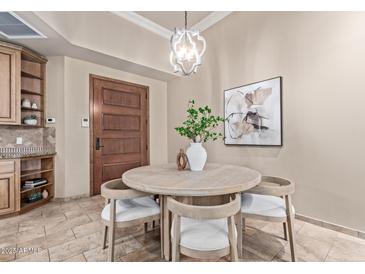 Cozy dining area featuring a round wood table, stylish chandelier, and neutral decor at 12625 N Saguaro Blvd # 203, Fountain Hills, AZ 85268