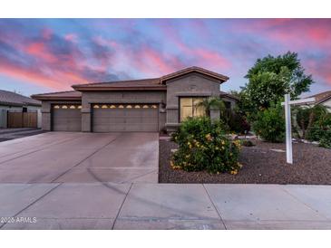 Charming home with three-car garage and landscaped front yard under a dramatic sunset sky at 1528 E Harrison St, Gilbert, AZ 85295