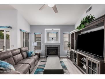 Inviting living room featuring a fireplace, large TV, neutral paint, and a comfortable sofa at 1773 E Constitution Dr, Chandler, AZ 85225