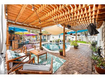 Relaxing backyard under wood pergola with lounge area, built in bar, and a refreshing swimming pool at 3126 N 17Th Dr, Phoenix, AZ 85015