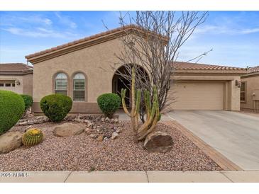 Charming home exterior features a well-manicured desert landscape and attached two-car garage at 4515 E Rakestraw Ln, Gilbert, AZ 85298