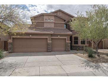 Inviting two-story home features a three-car garage, desert landscaping, and neutral-toned exterior at 8339 W Molly Ln, Peoria, AZ 85383