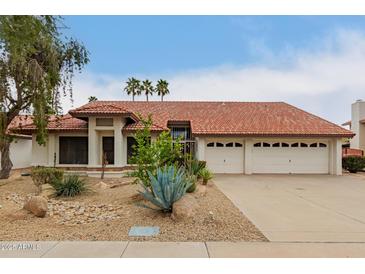 Charming single-story home featuring a well maintained landscaped yard and an attached three-car garage at 8861 E Sutton Dr, Scottsdale, AZ 85260