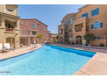 Charming community pool area with residential buildings in the background at 240 W Juniper Ave # 1053, Gilbert, AZ 85233