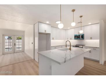 Stylish kitchen with white cabinets, quartz countertops, and stainless steel appliances at 2416 S Evergreen Rd, Tempe, AZ 85282