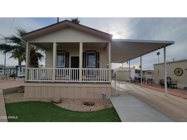 Charming single story home with covered porch, manicured lawn, and a convenient carport at 2460 E Main St # F7, Mesa, AZ 85213