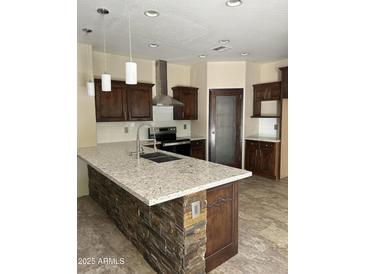 Modern kitchen features dark cabinets, stainless steel appliances, stone accents, and a large island at 7163 W Lamar Rd, Glendale, AZ 85303