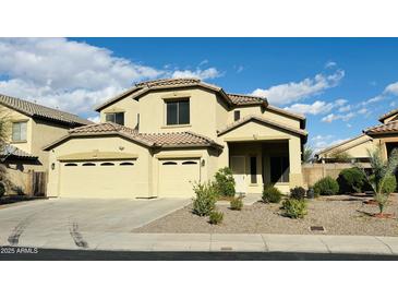 Two-story home featuring a three-car garage and a well-maintained, xeriscaped front yard, perfect for low-maintenance living at 7511 S 45Th Dr, Laveen, AZ 85339