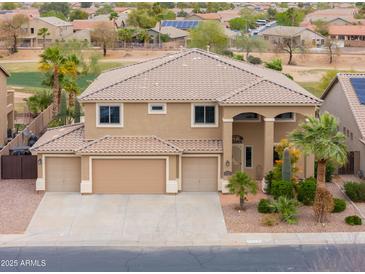 Inviting two-story home with a three-car garage, desert landscaping, and a tile roof at 22139 N O Sullivan Dr, Maricopa, AZ 85138