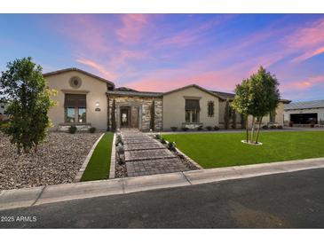 Stunning single-story home with lush lawn, mature trees, and a charming stone-accented entrance at 4023 E Minton Cir, Mesa, AZ 85215